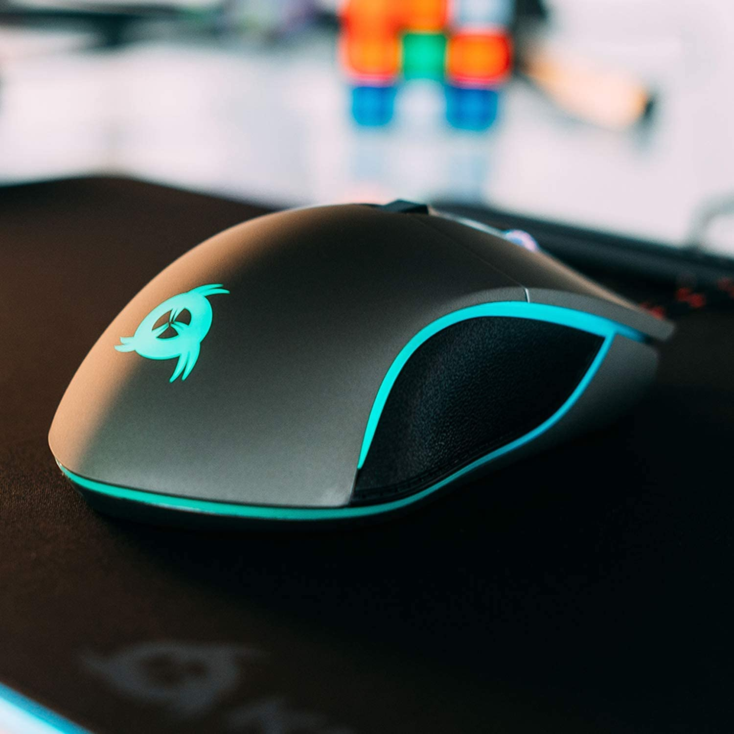 Schwarze Gaming-Maus mit türkisfarbenen Akzenten und Logo auf schwarzer Oberfläche.