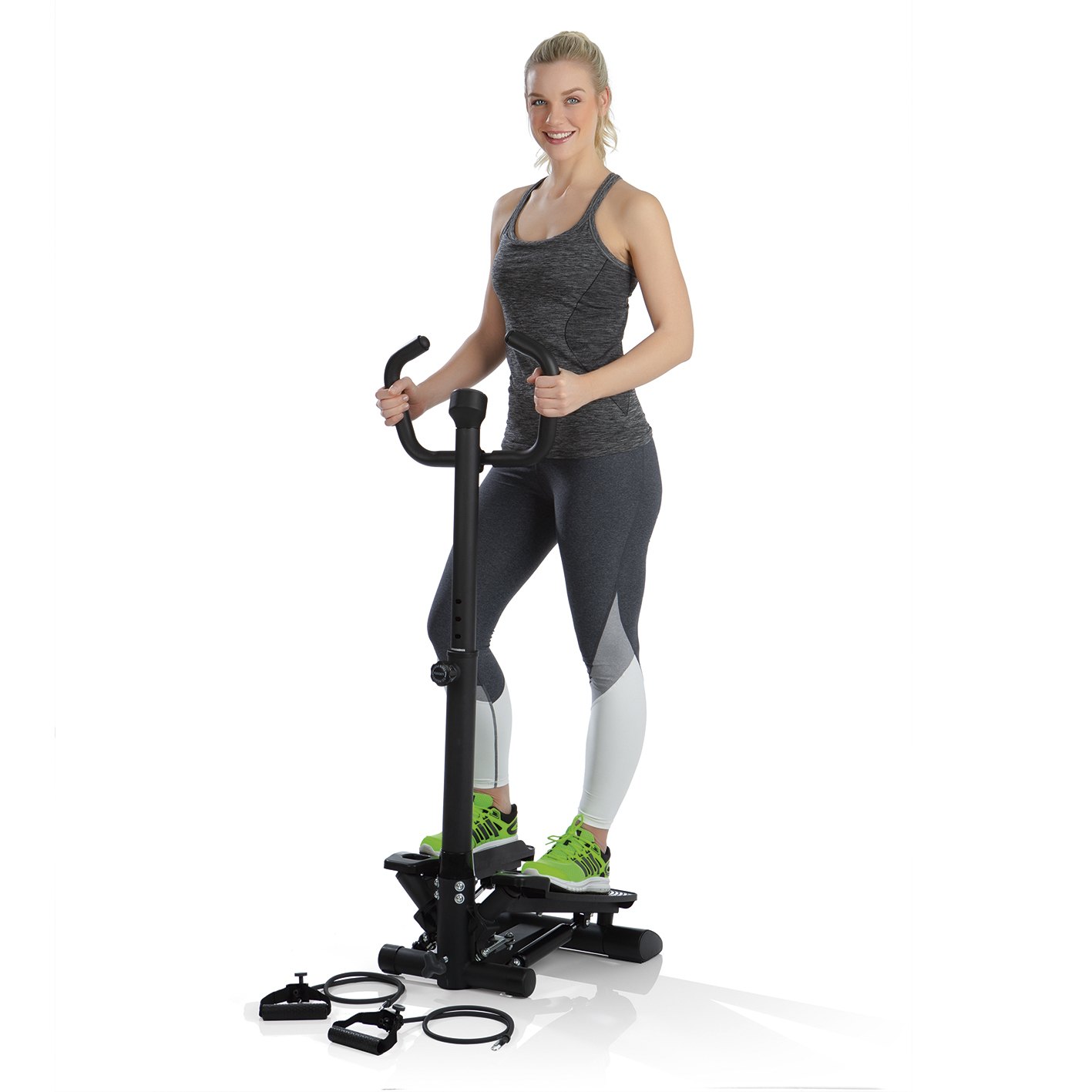 Eine Frau, die auf einem Stepper trainiert. Sie trägt ein graues Oberteil und Leggings. Der Stepper ist schwarz, und grüne Turnschuhe.