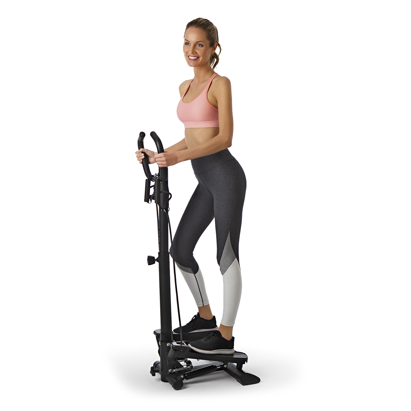 Frau benutzt eine Stepper-Maschine. Sie trägt Sportkleidung und lächelt.