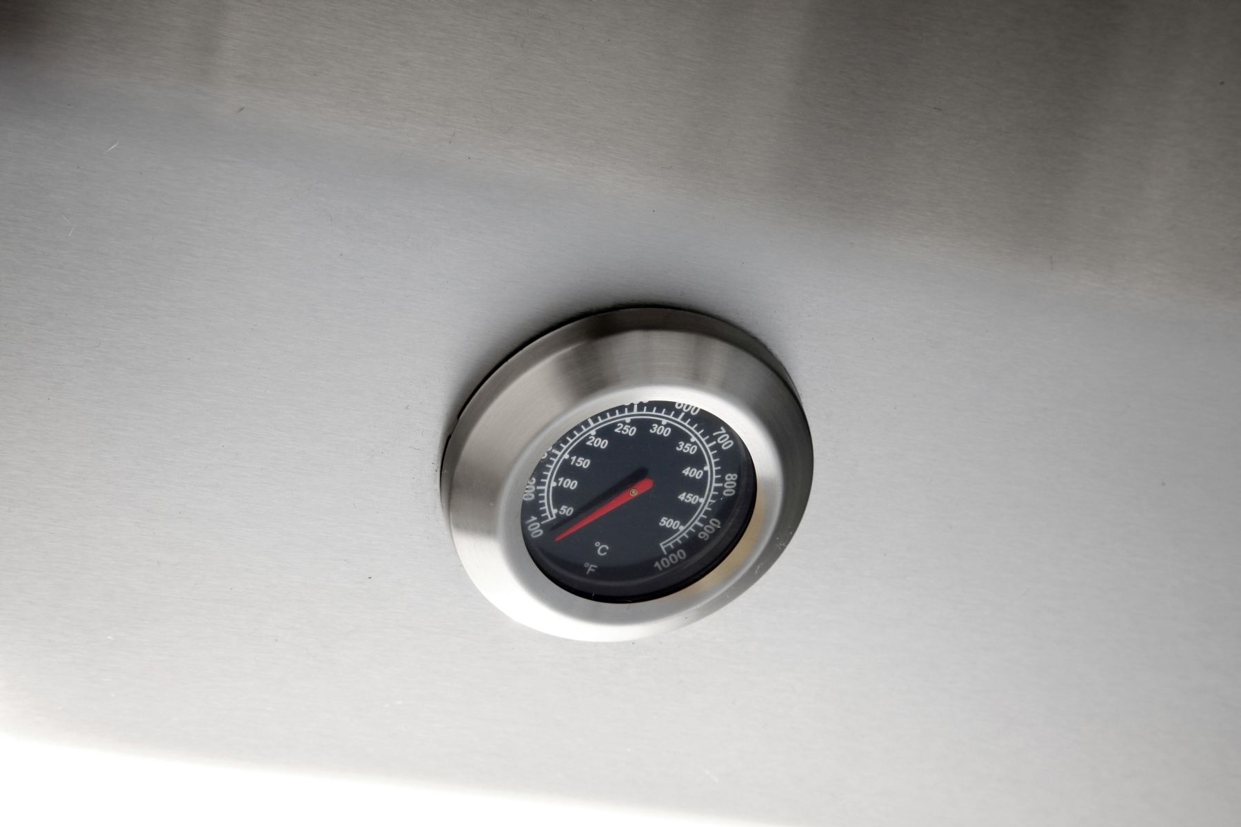 Ein Thermometer auf einer Edelstahloberfläche, das etwa 400 Grad anzeigt.