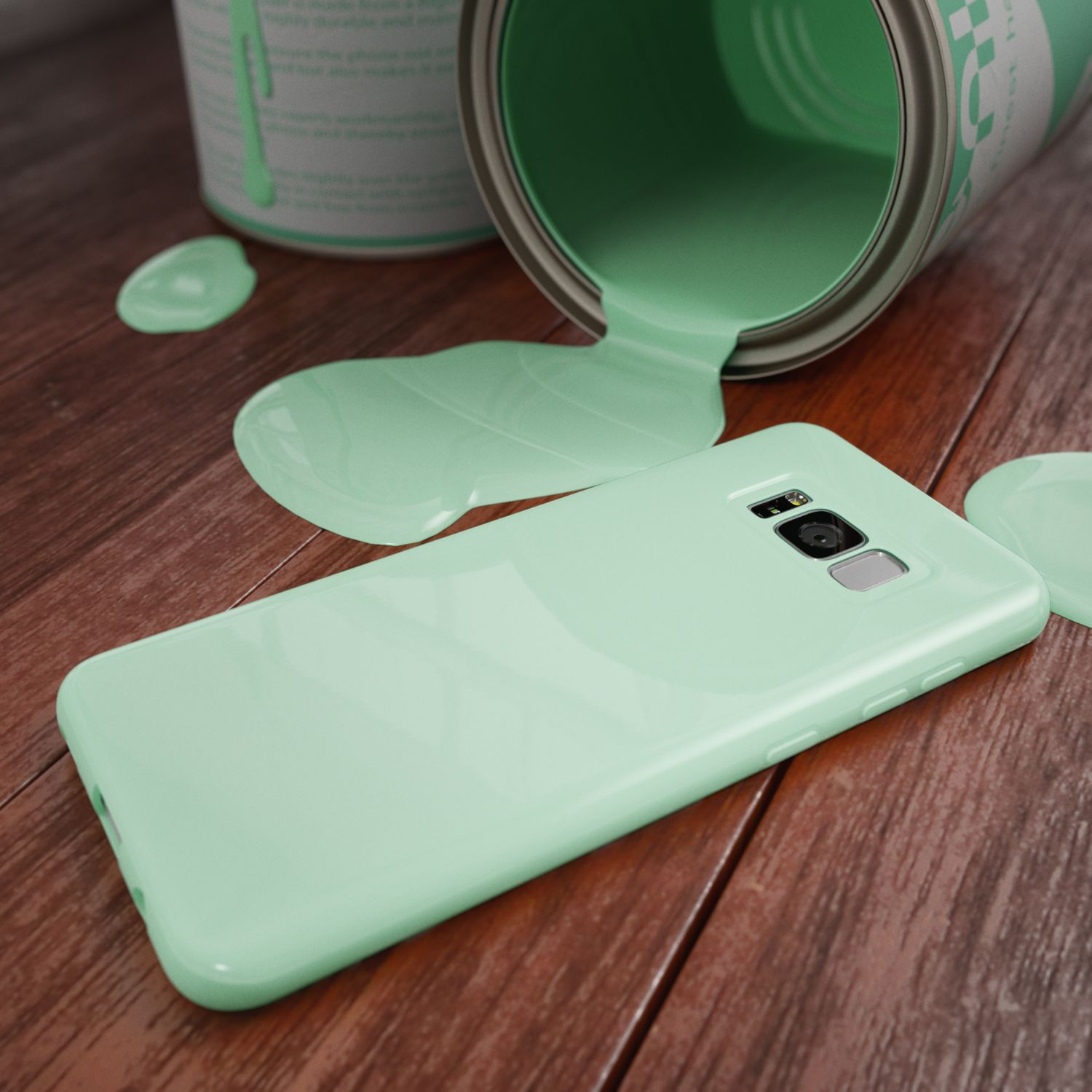 Grüne Farbe läuft aus einer Dose auf eine passende Handyhülle auf Holz.