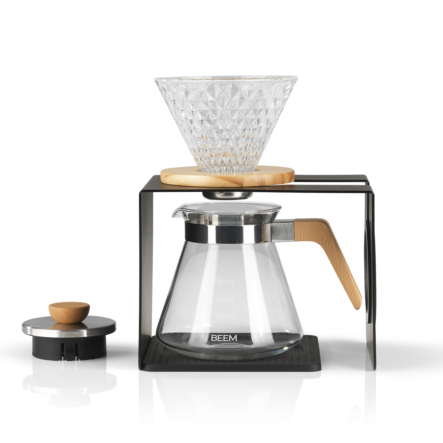 Glas-Kaffeemaschine mit Holzgriff. Ein schwarzer Metallständer stützt das Glas.