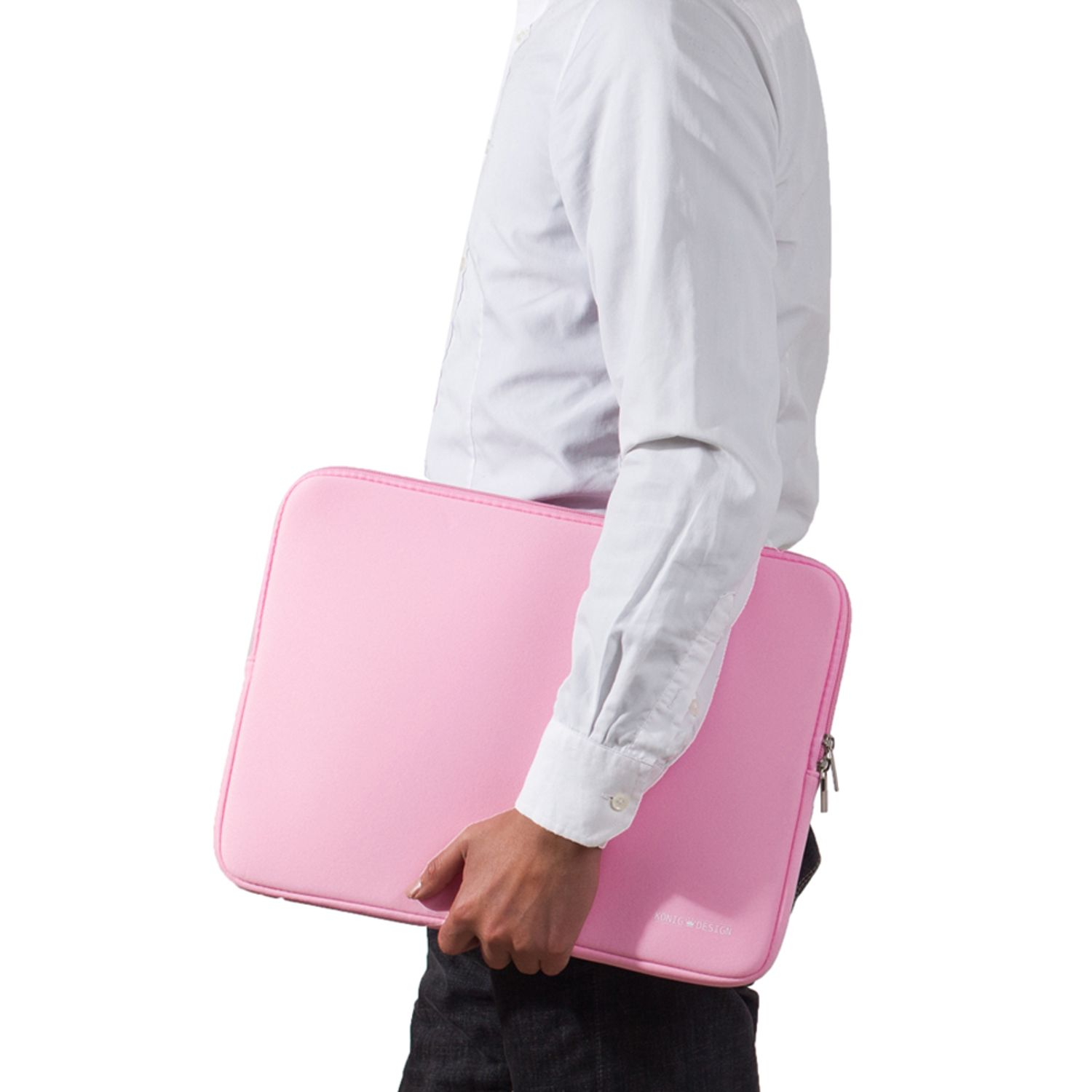 Eine Person hält eine rosa Laptoptasche. Die Person trägt ein weißes Hemd und dunkle Hosen.
