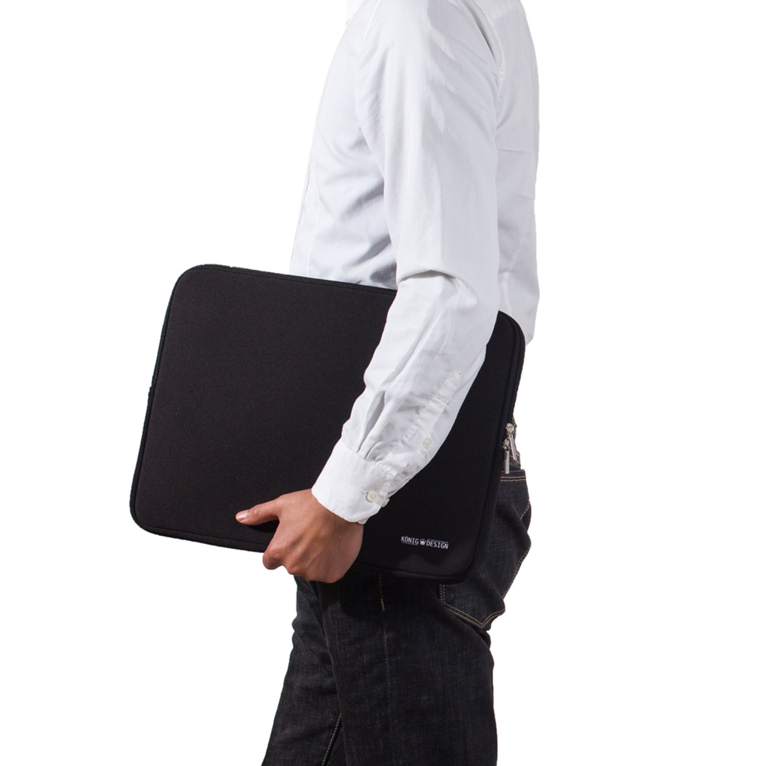 Eine Person hält eine schwarze Laptop-Hülle mit einem Konko Design-Logo. Jeans und ein weißes Hemd.