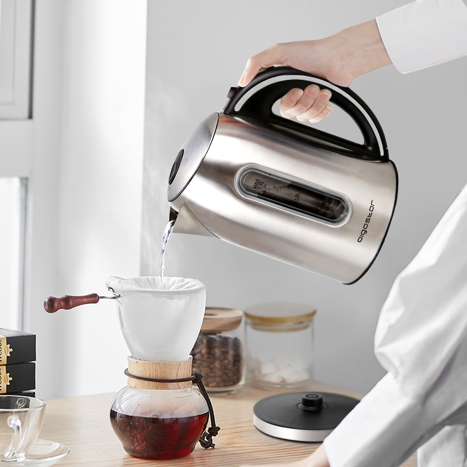 Una persona versa l'acqua da un bollitore in un filtro. Preparazione del caffè sullo sfondo.