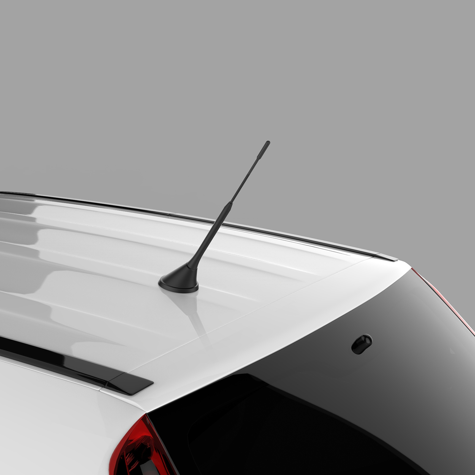 Eine schwarze Autoantenne auf einem weißen Autodach, mit sichtbarer Heckscheibe.