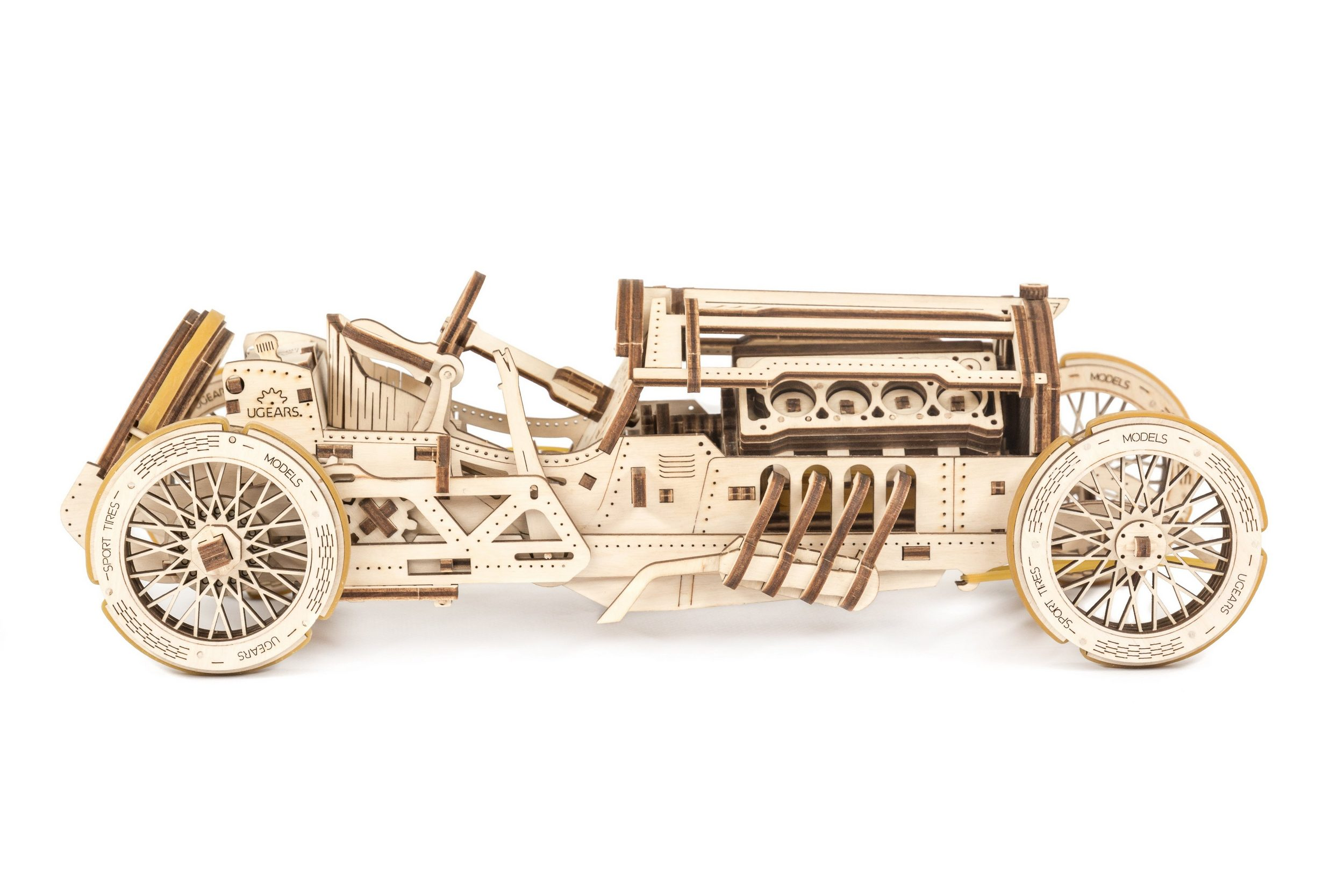 Ein Holzmodellauto, Seitenansicht. Es ist ein Oldtimer-Rennwagen.