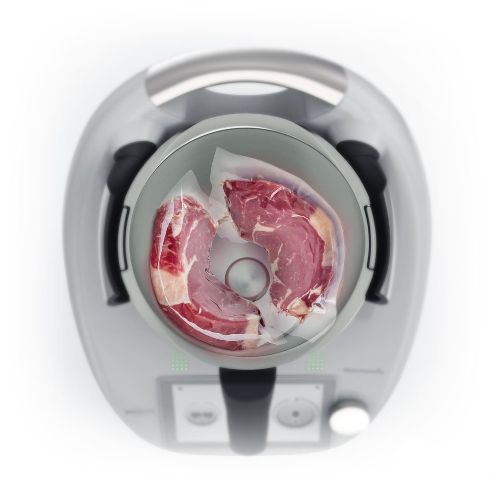 Un elettrodomestico da cucina con una bistecca cruda in un sacchetto sigillato all'interno di una ciotola.