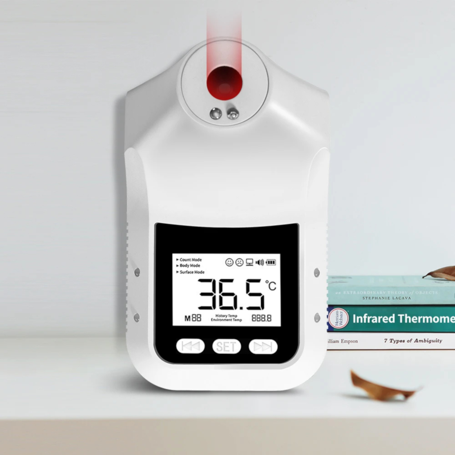 Weißes, an der Wand montiertes Infrarot-Thermometer mit Digitalanzeige, die 36,5 °C anzeigt.