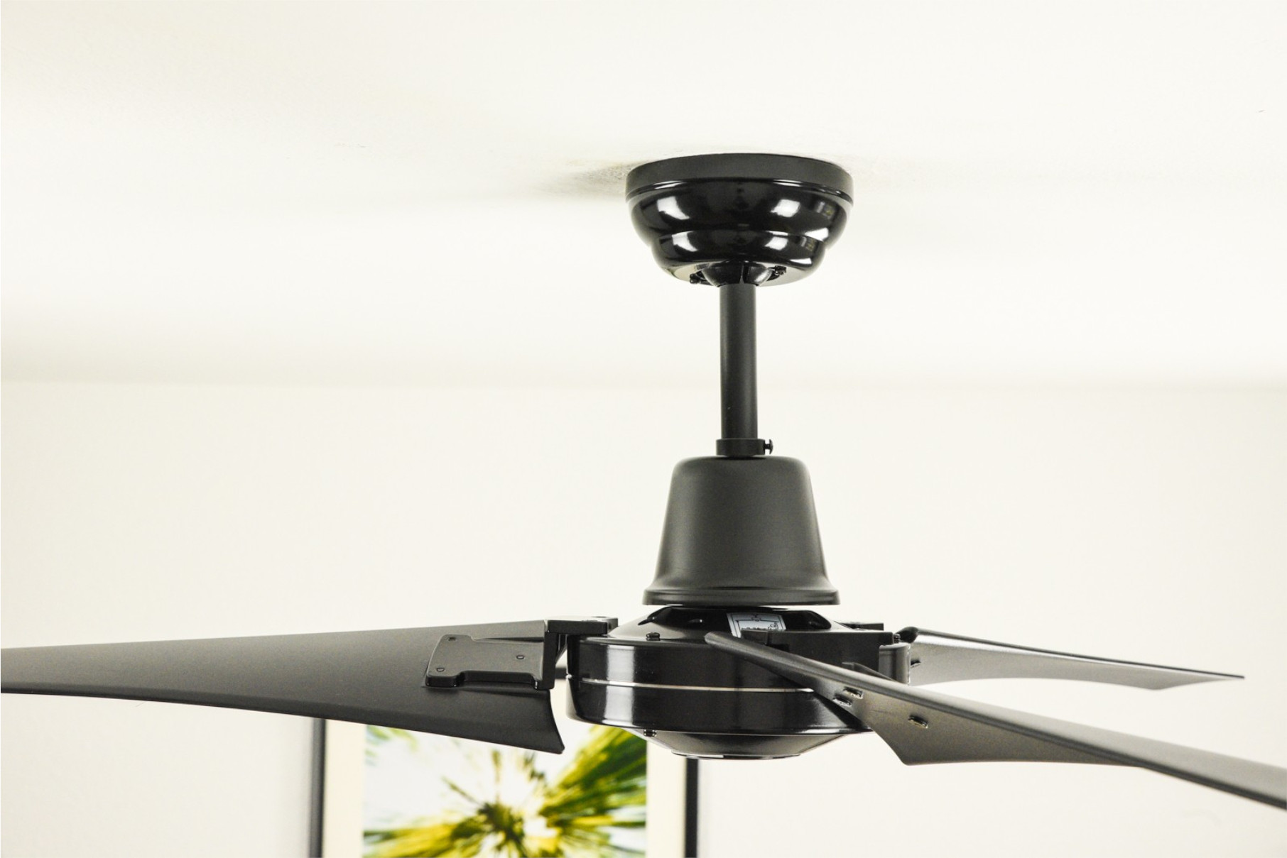 Schwarzer Deckenventilator mit vier Flügeln.