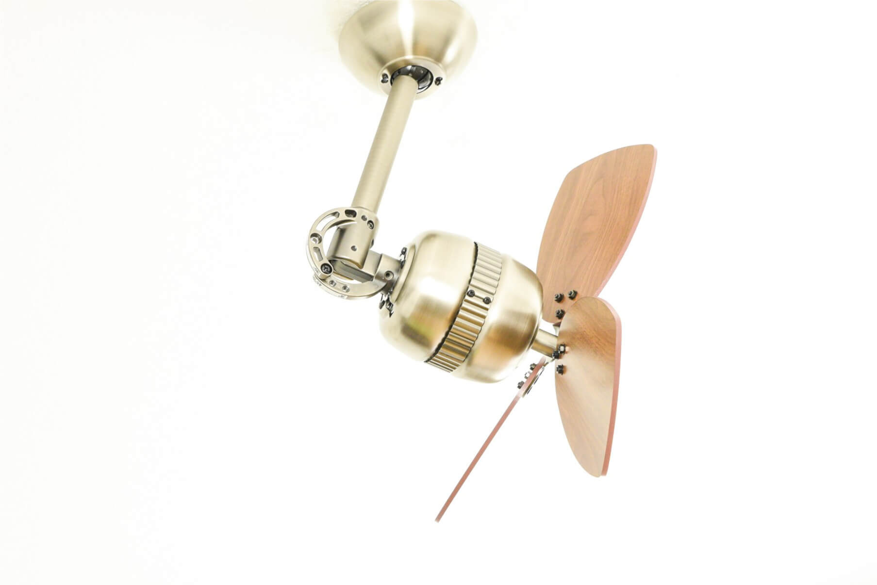 Ventilatore a soffitto con due pale in legno, attacco in ottone e soffitto bianco sullo sfondo.