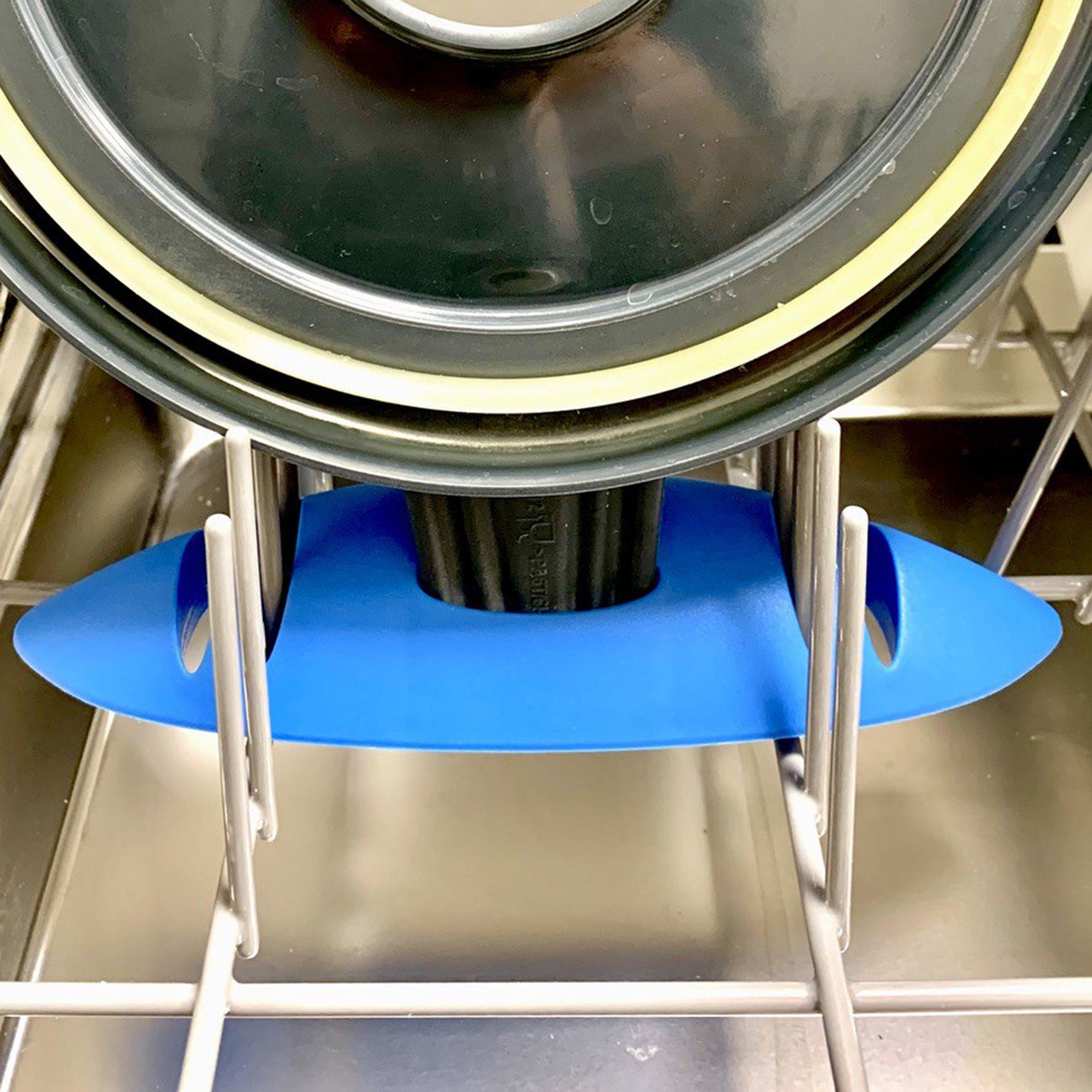 Un oggetto di plastica blu posto all'interno di una lavastoviglie. Tiene un coperchio.