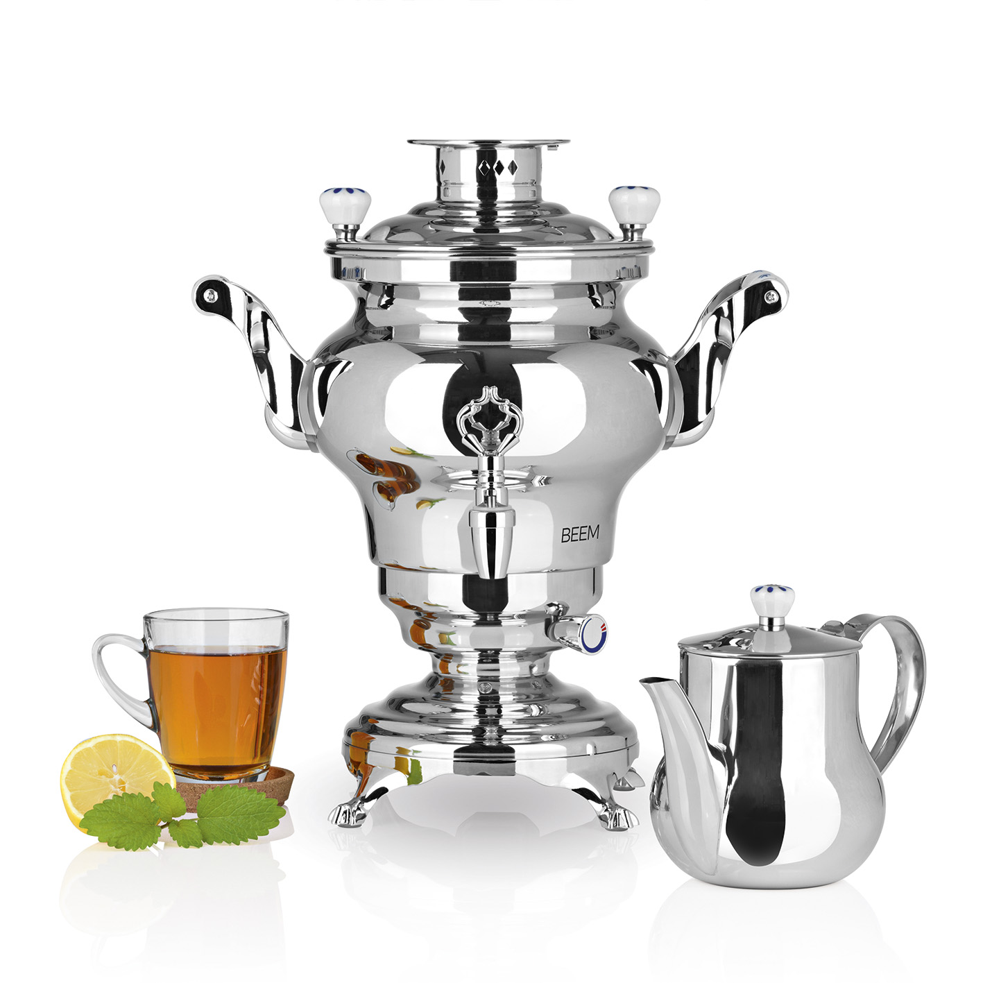 Ein silberner Samowar, Teetasse, Teekanne, Zitrone und Minzblätter auf weißem Hintergrund.
