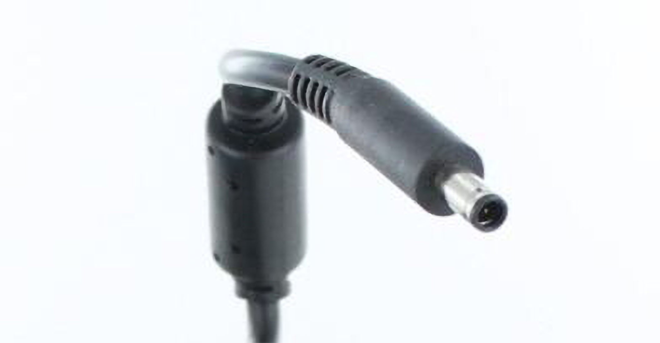 Czarny kabel zasilacza do laptopa ze złączem. Białe tło.