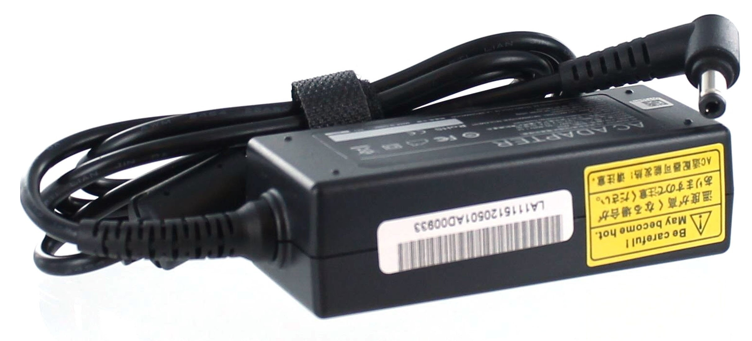 Ein schwarzer Netzadapter mit Kabel und gelbem Warnhinweis. Weißer Hintergrund.