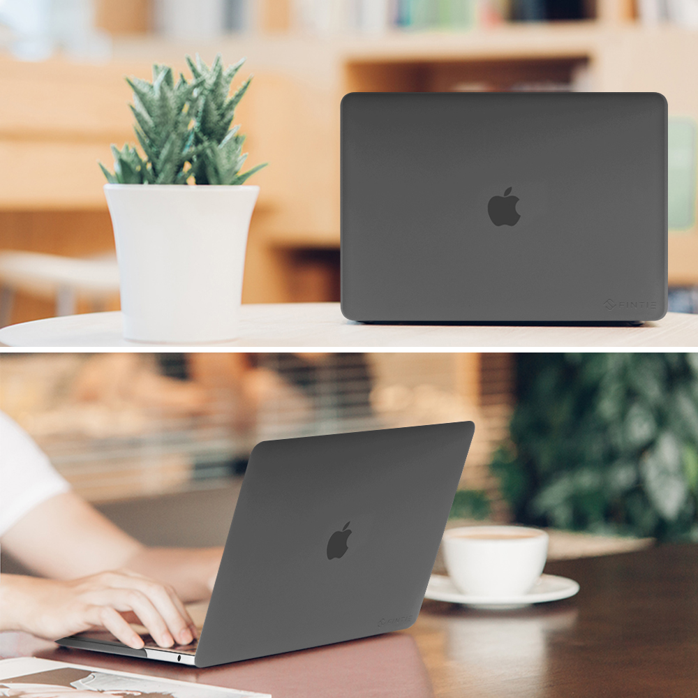 Ein Laptop mit grauem Gehäuse und Apple-Logo auf einem Holztisch mit Pflanze und Kaffeetasse.