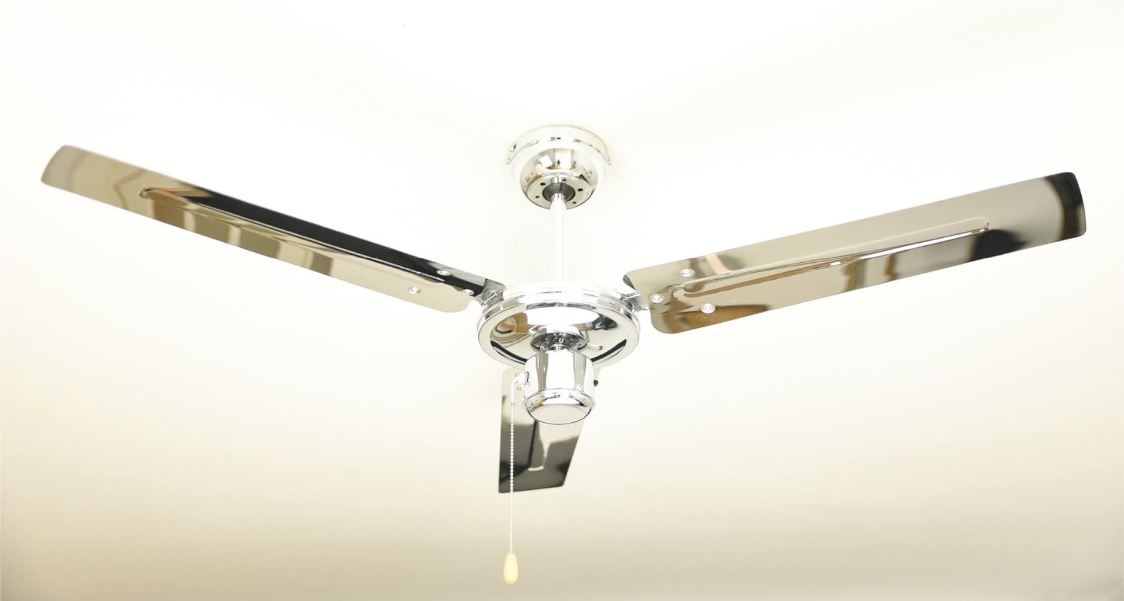 Deckenventilator mit Chrom-Finish, drei Flügel. Er ist an einer weißen Decke montiert.
