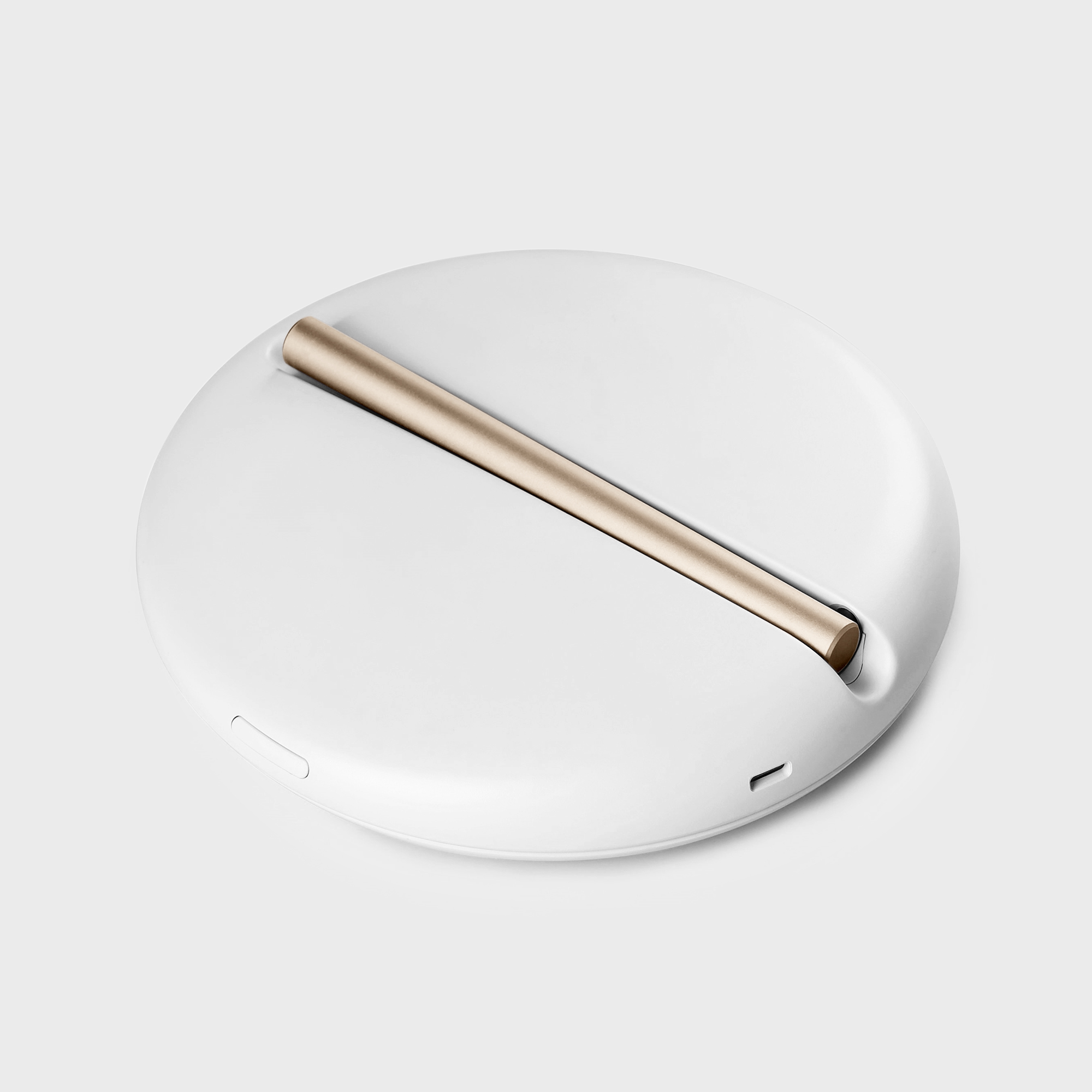 Weißes, kreisförmiges Gerät mit einem Goldbarren. Das Gerät hat ein schlankes, minimalistisches Design auf grauem Hintergrund.