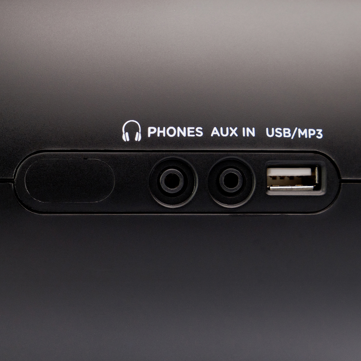 Dispositivo negro con puertos de auriculares, aux in y USB. Fondo blanco.
