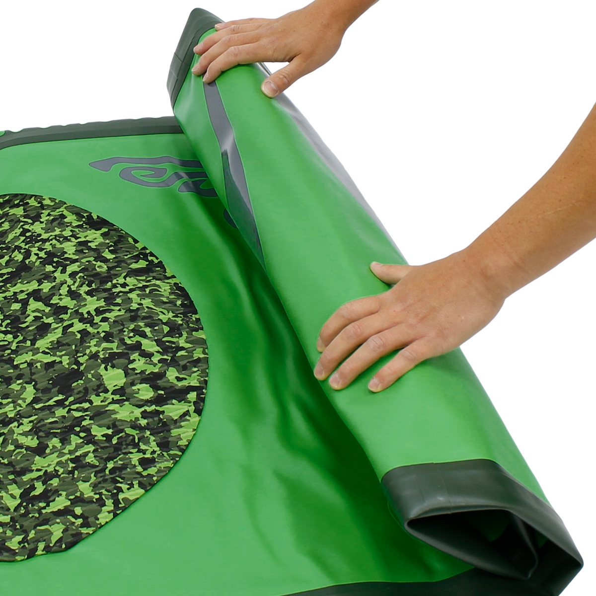 Hände rollen eine grüne Matte mit einem Tarnkreismuster auf weißem Hintergrund aus.