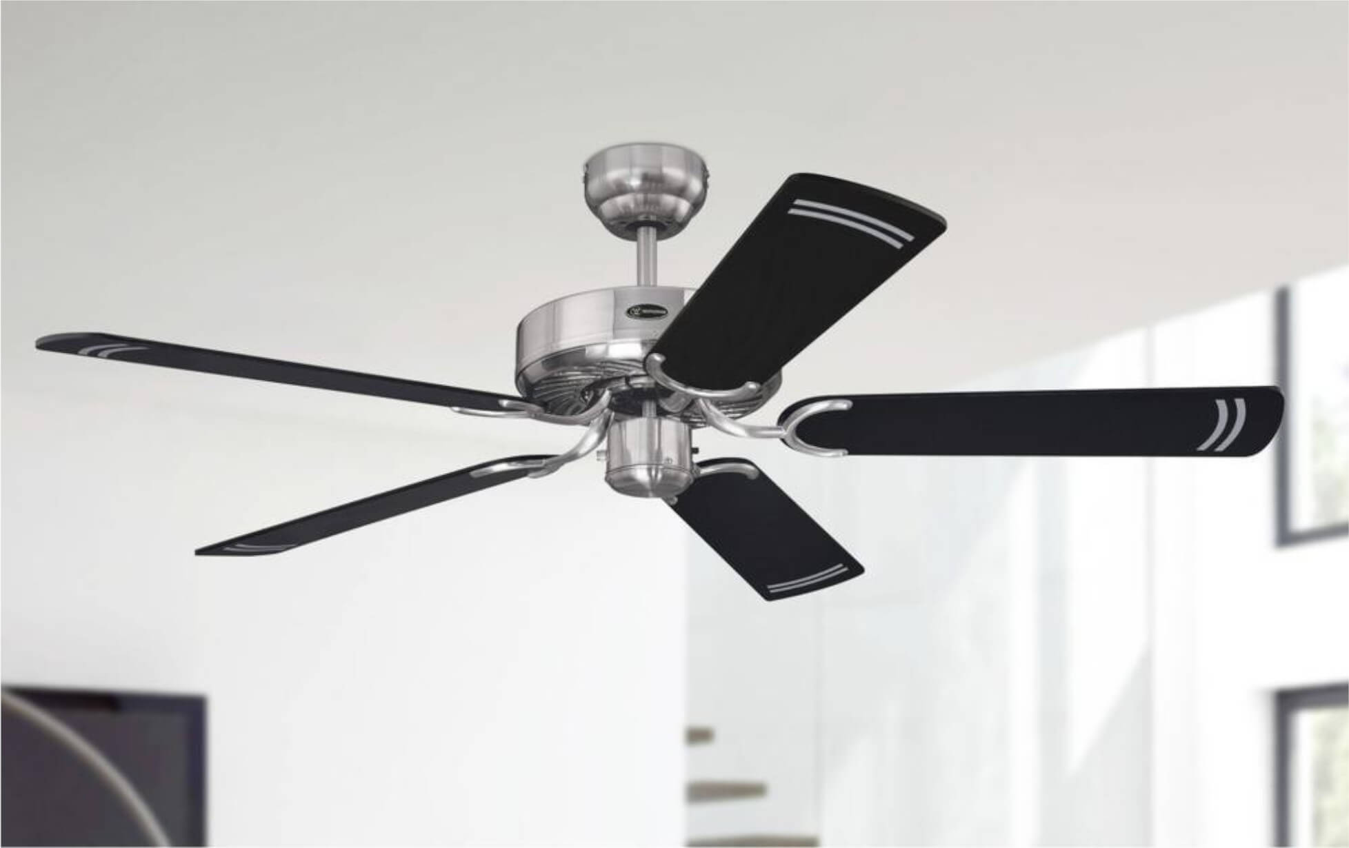 Deckenventilator mit silbernem Motor und schwarzen Blättern mit weißen Streifen, vor weißem Hintergrund.