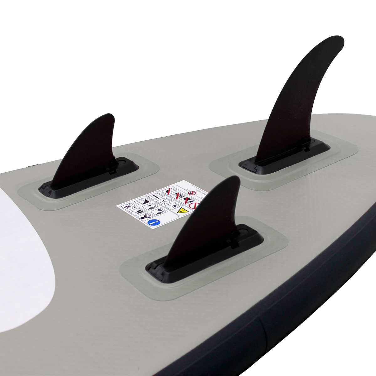 Ein graues Paddleboard mit drei schwarzen Flossen an der Unterseite und einem Warnhinweis.