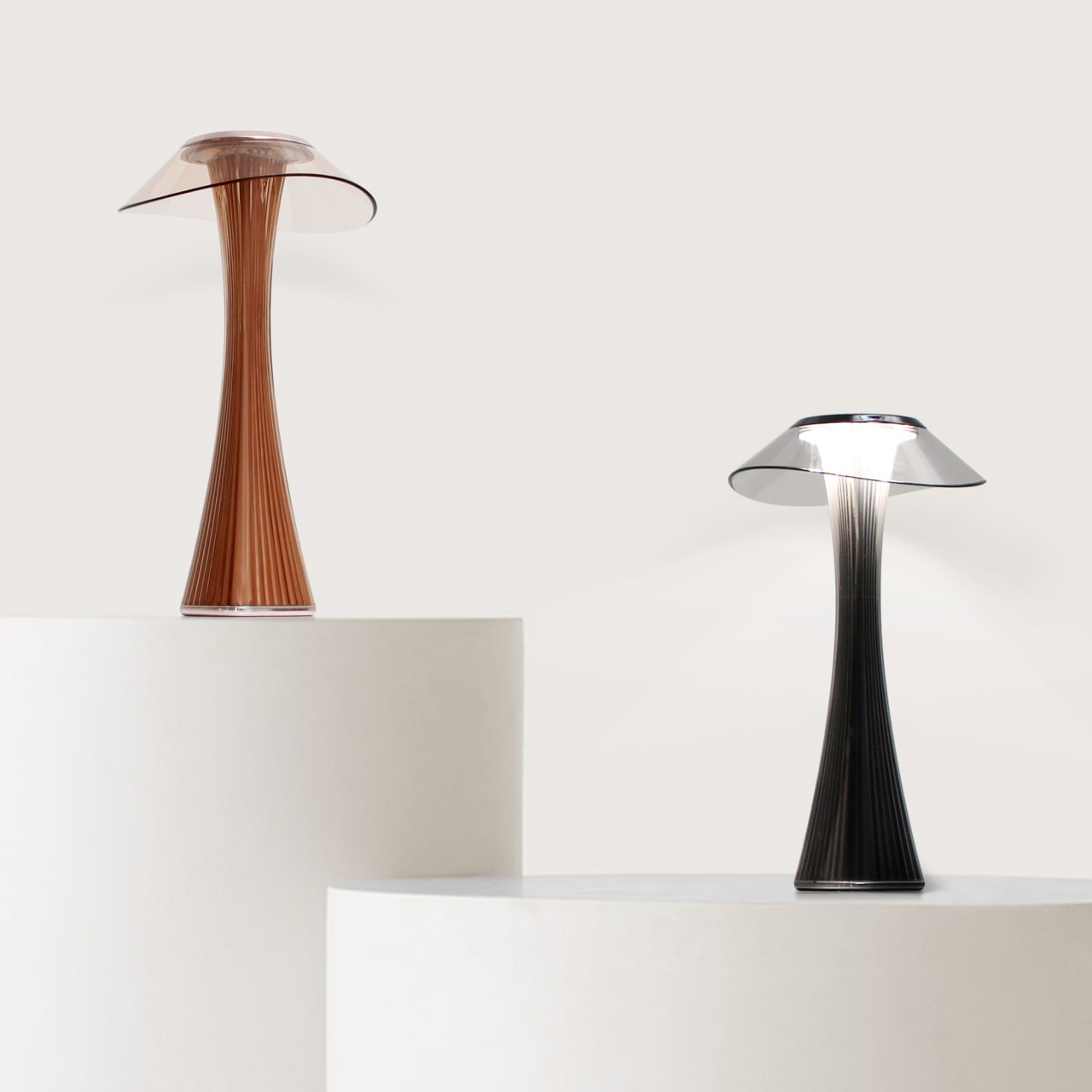 Zwei moderne Lampen auf Podesten. Eine ist braun, die andere schwarz, beide mit pilzförmigem Design.