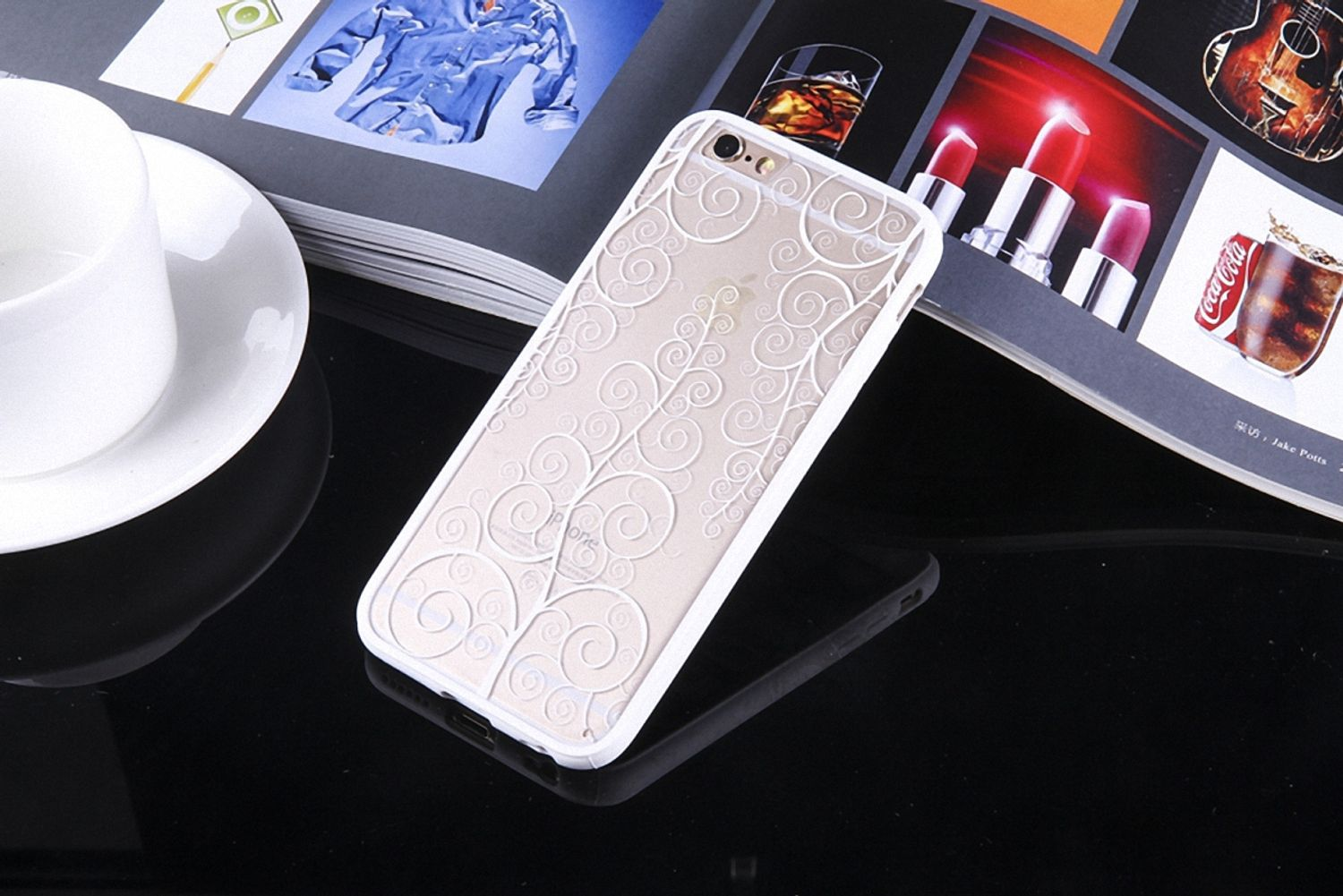 Eine transparente Handyhülle mit weißem Blumendesign auf reflektierender Oberfläche.