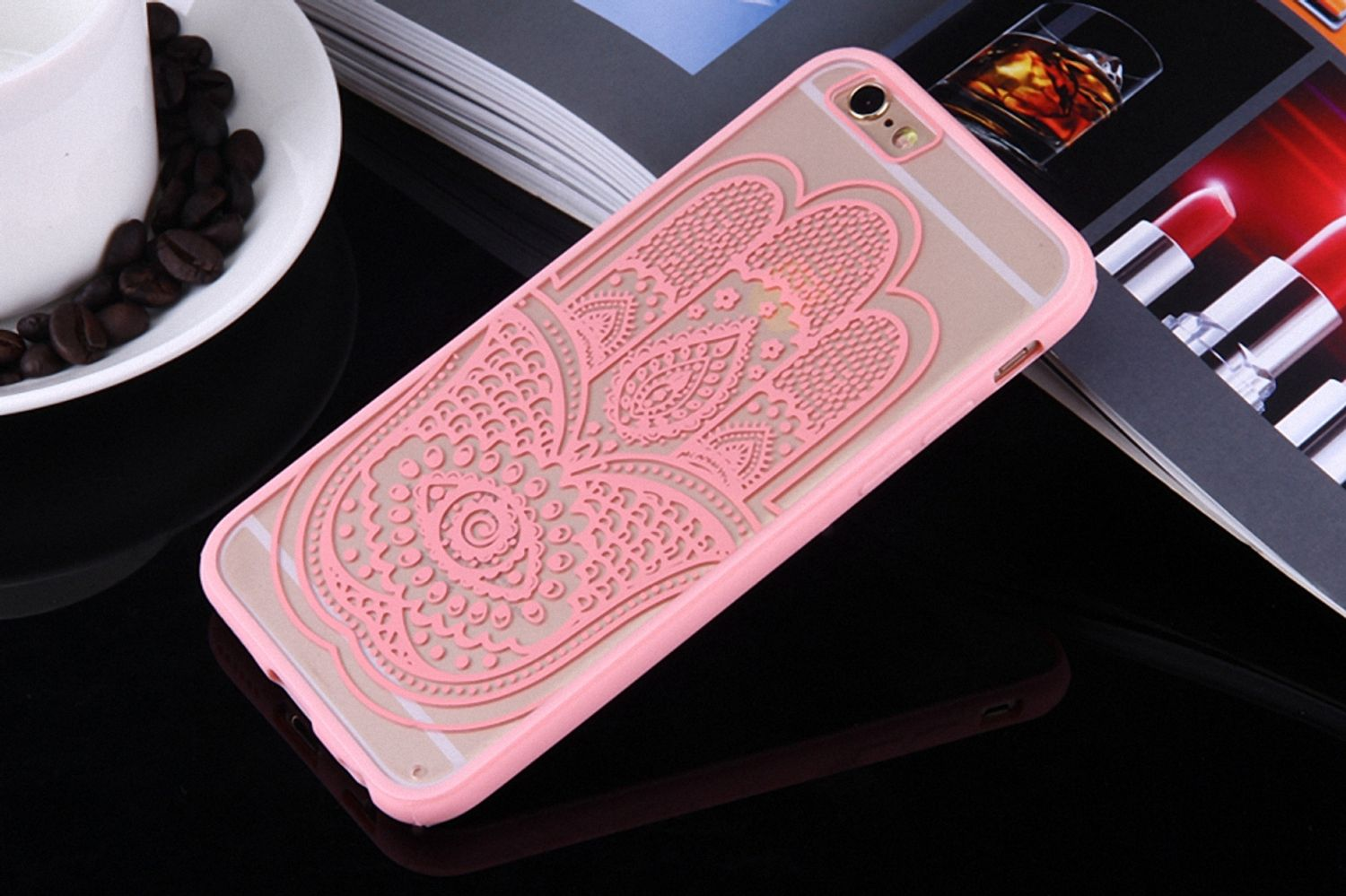 Rosa Handyhülle mit Hamsa-Hand-Design. Hülle auf Tisch mit Kaffee und Lippenstift.
