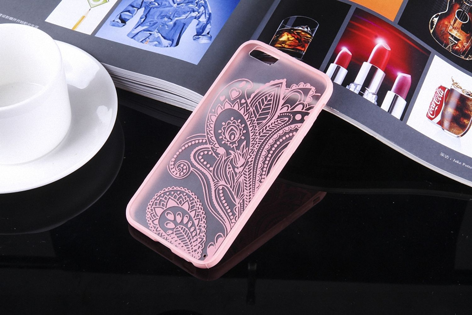 Rosa Handyhülle mit floralem Design. Die Hülle liegt auf einem Tisch.