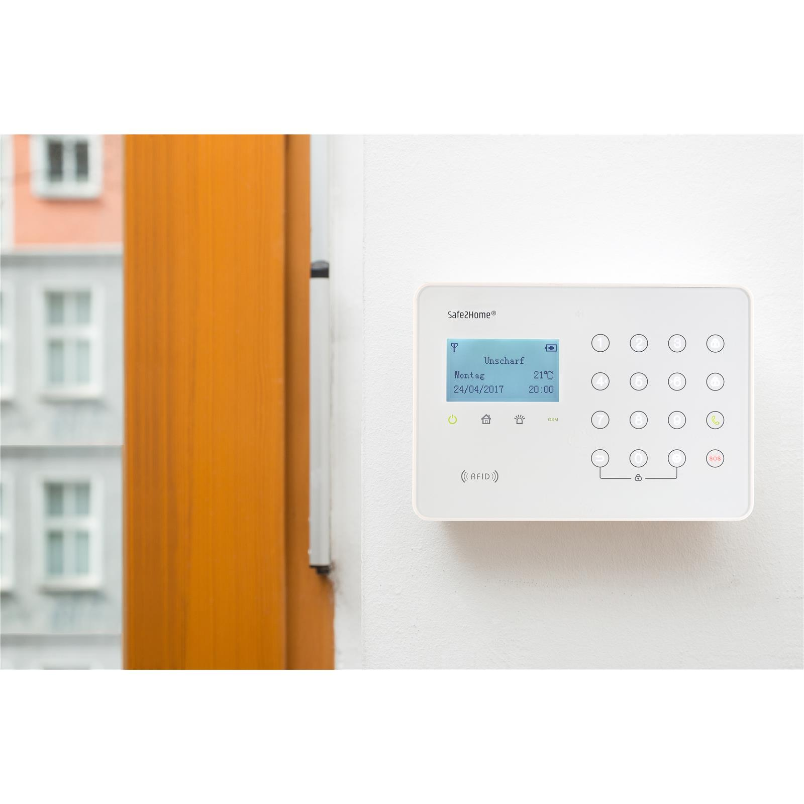 Weißes Bedienfeld eines Sicherheitssystems an einer Wand. Zeigt Zeit, Datum und andere Einstellungen an.
