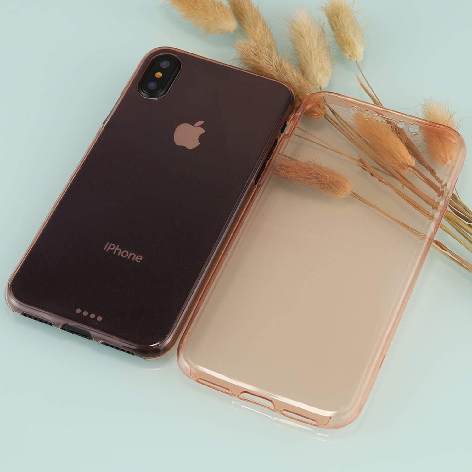 Zwei Handyhüllen: eine durchsichtige, eine braune. Die Hüllen liegen neben einem Telefon mit brauner Rückseite.