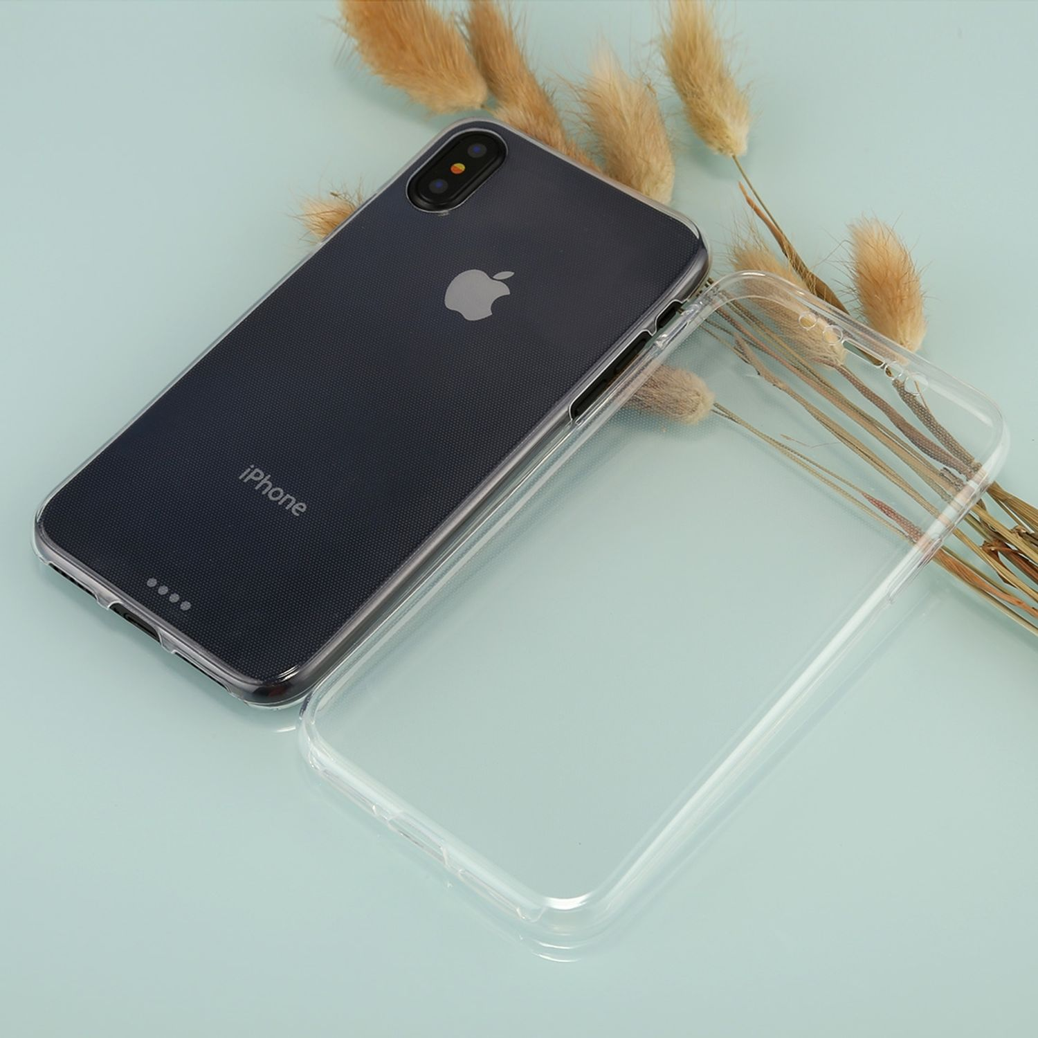 Schwarzes Telefon mit transparenter Hülle. Das Telefon liegt auf hellblauem Untergrund.