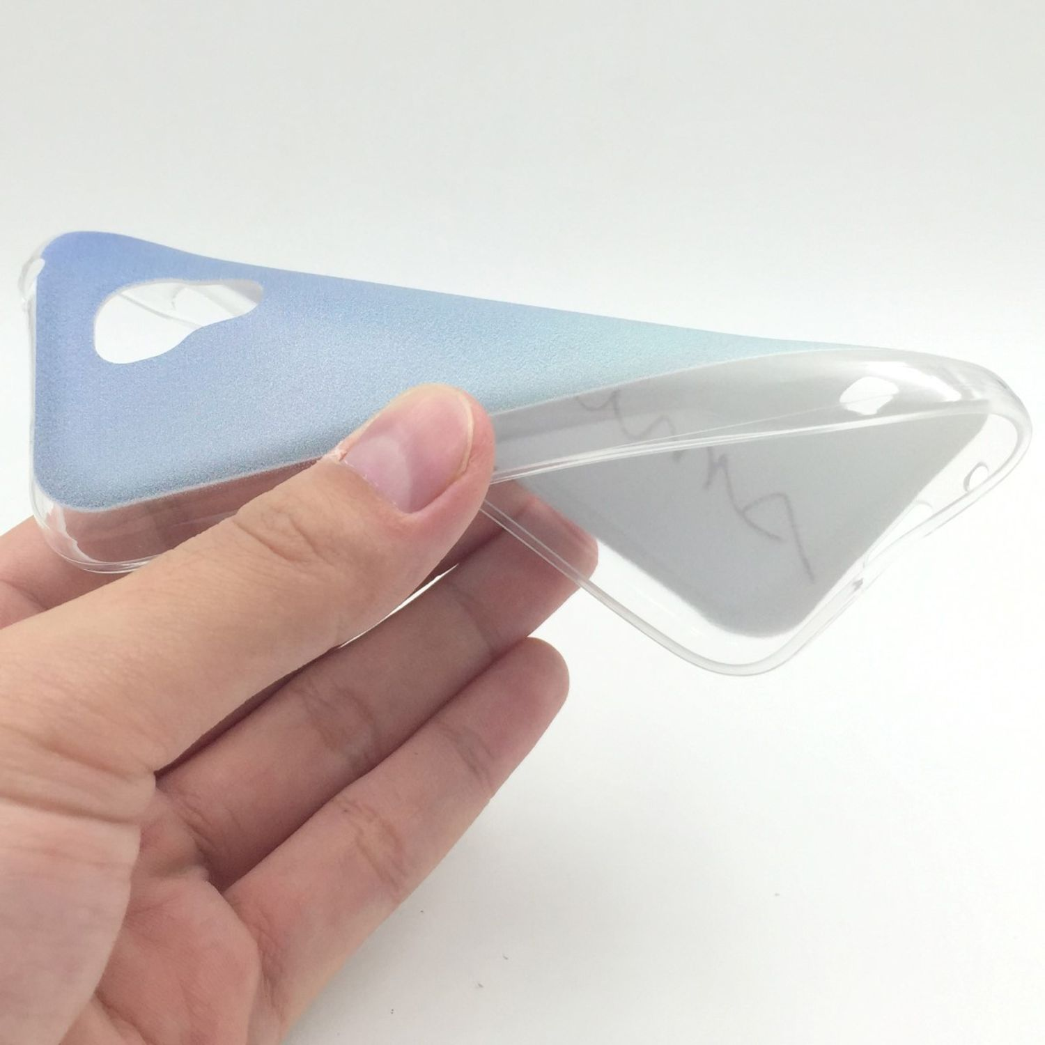 Hand hält eine transparente Handyhülle mit blauem Farbverlauf. Weißer Hintergrund.