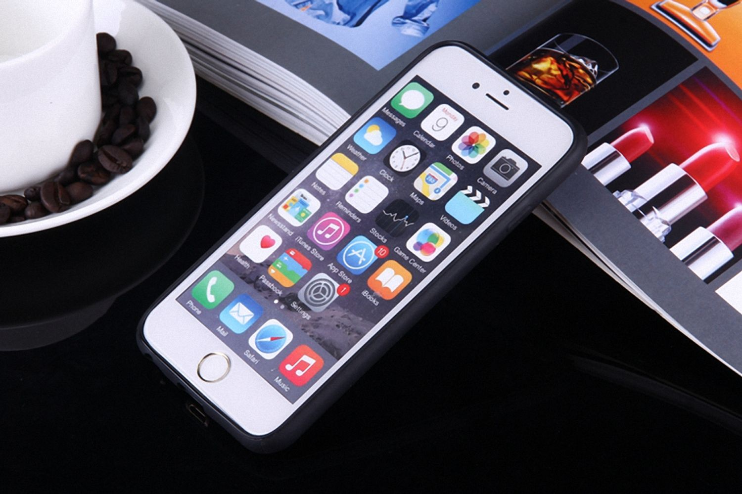 iPhone auf glänzender Oberfläche, Kaffee und Zeitschriften im Hintergrund.