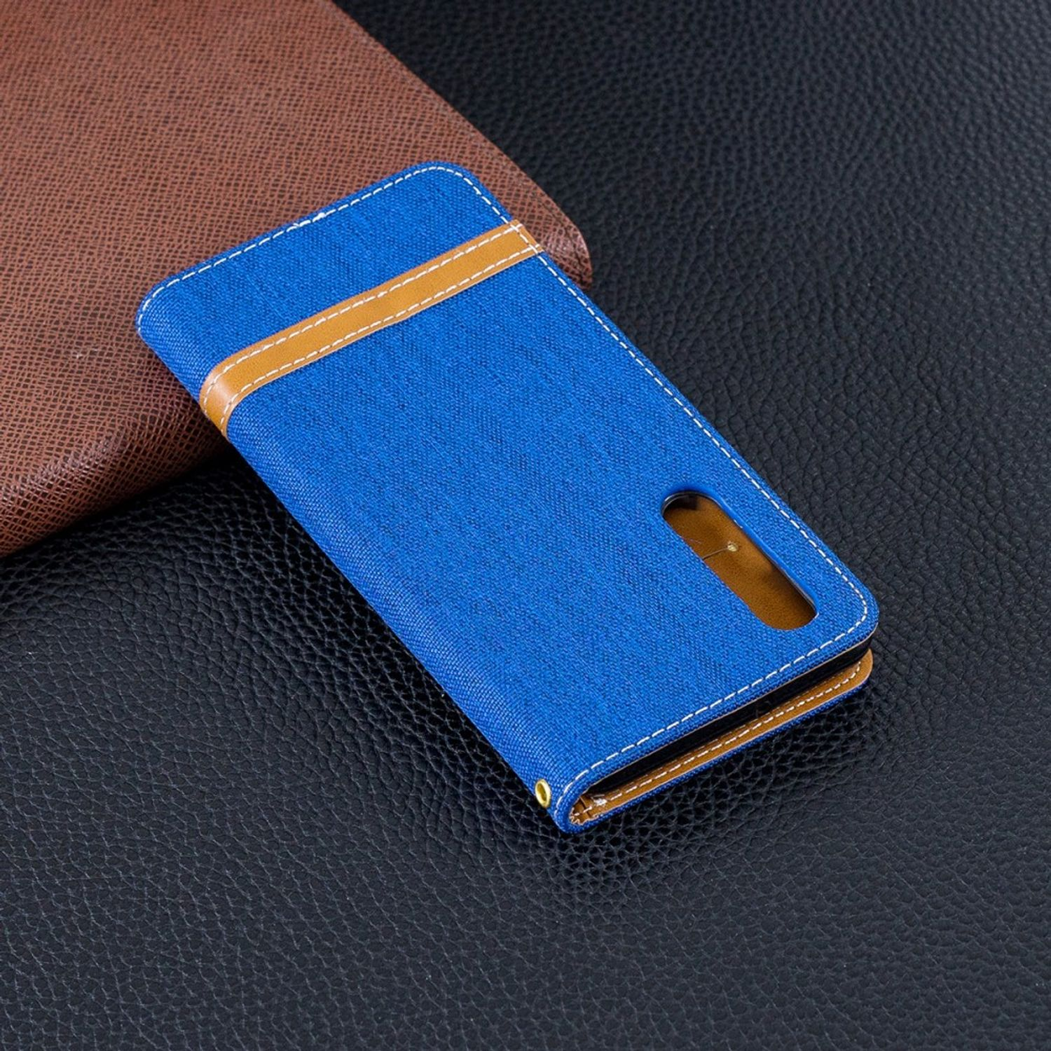 Blaue Handyhülle mit braunen Akzenten auf dunkler Oberfläche.