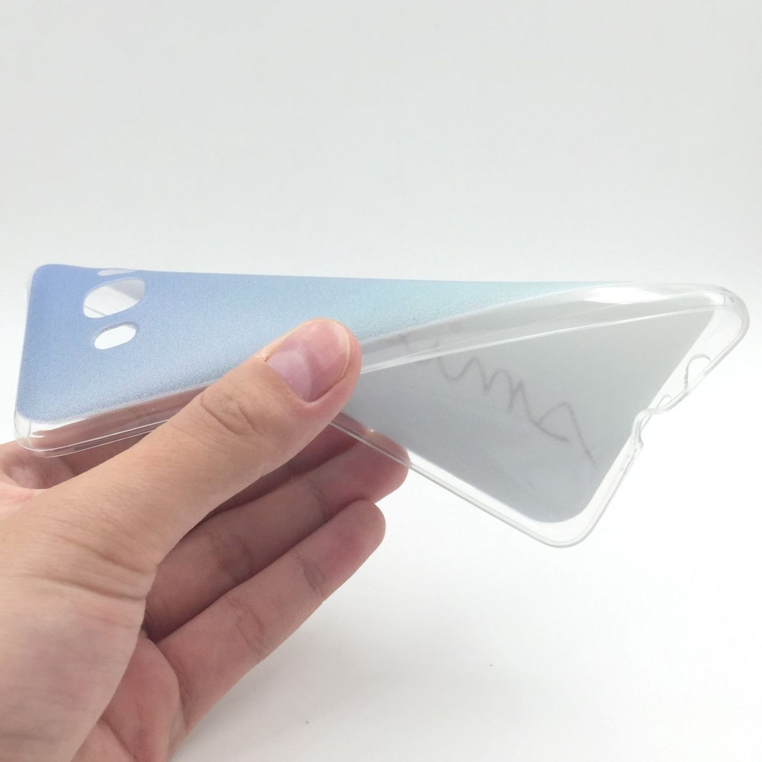 Hand hält eine Handyhülle. Die Hülle ist transparent mit einem blau-weißen Farbverlauf.