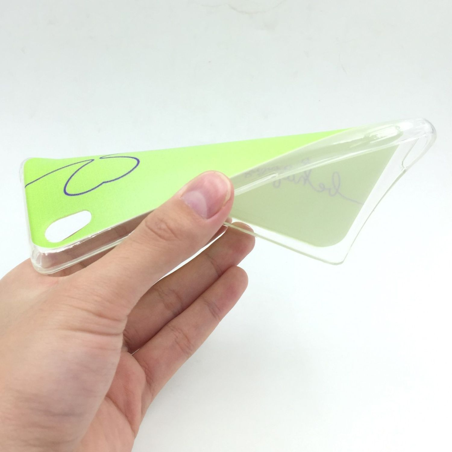 Hand hält eine hellgrüne Handyhülle mit Design. Weißer Hintergrund.