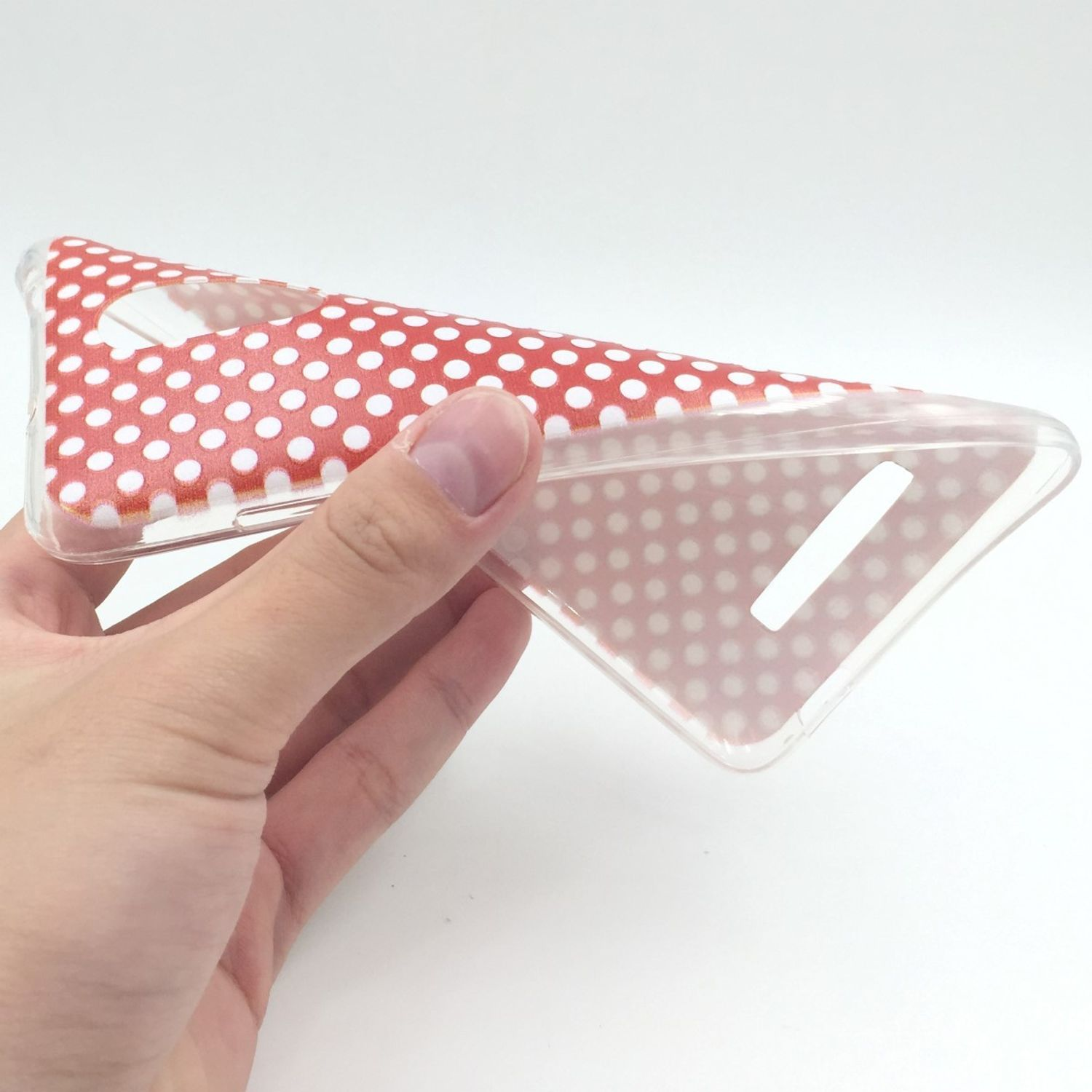 Hand hält eine transparente Handyhülle mit roten Punkten auf weißem Hintergrund.