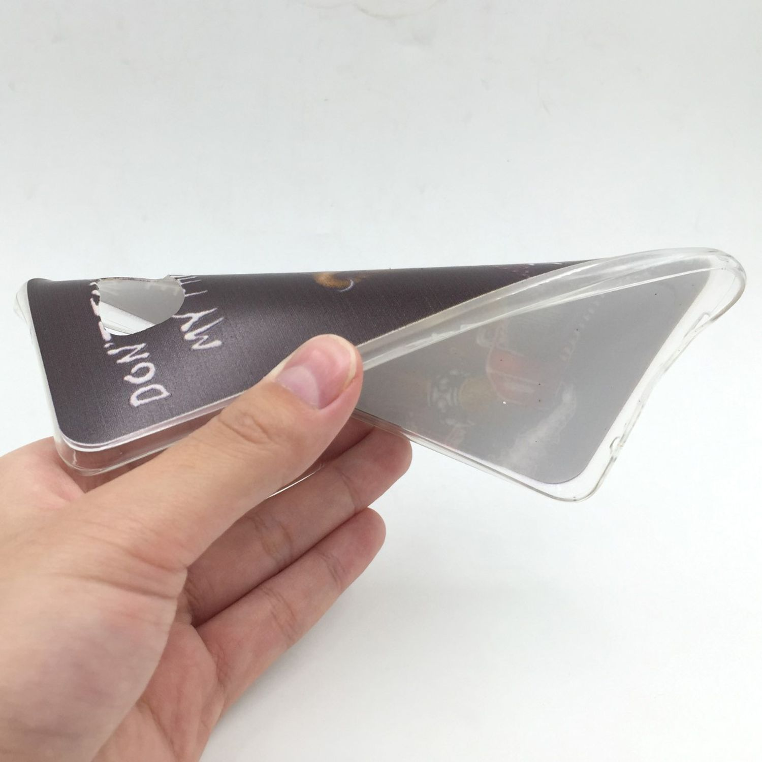 Hand hält eine transparente Handyhülle mit Design. Weißer Hintergrund.