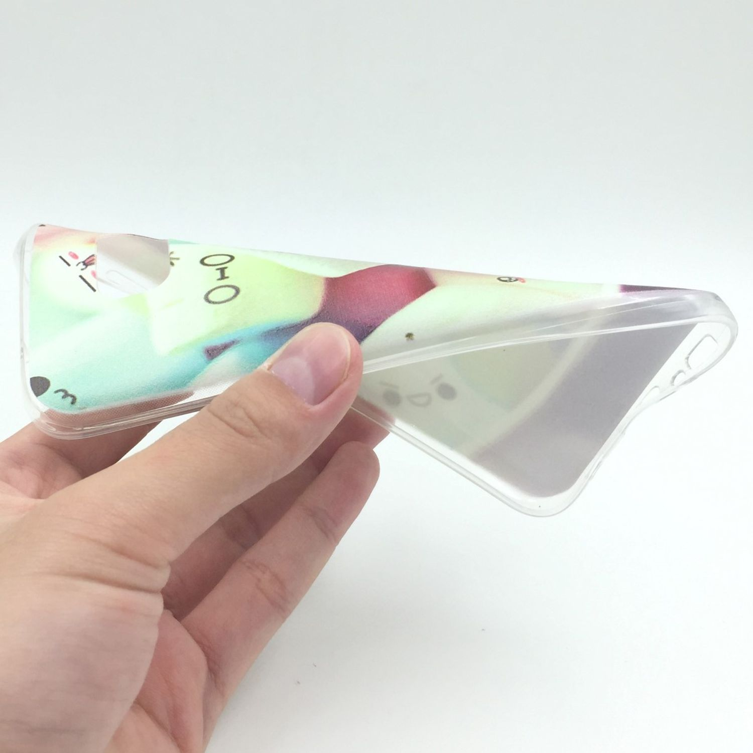 Eine Hand hält eine transparente Handyhülle mit Cartoon-Design, heller Hintergrund.