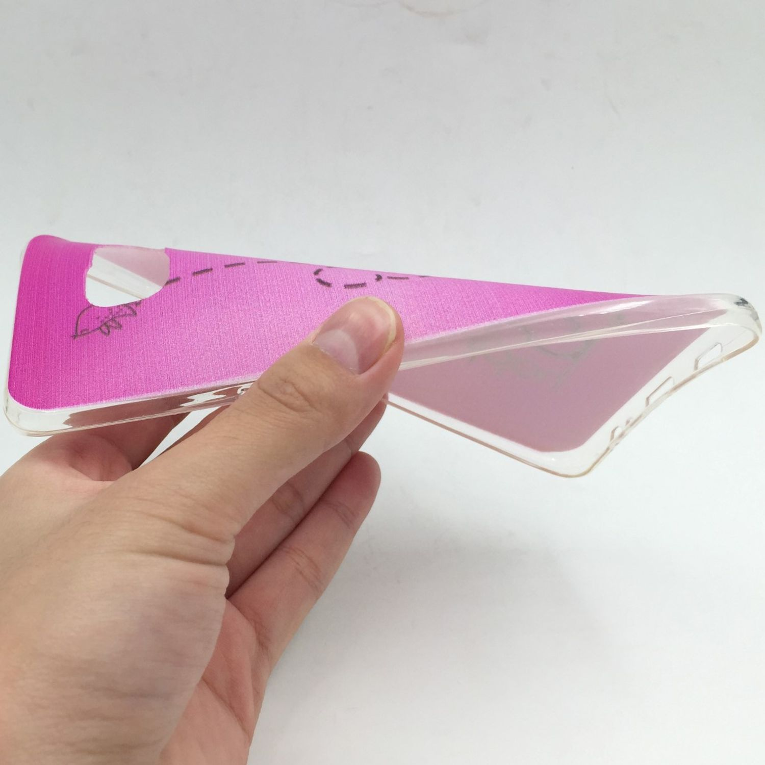 Hand hält transparente Handyhülle mit pinkem Design. Weißer Hintergrund.