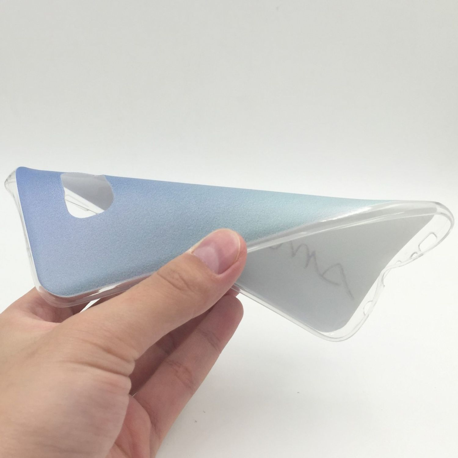 Hand hält eine Handyhülle mit blau-weißem Farbverlauf.