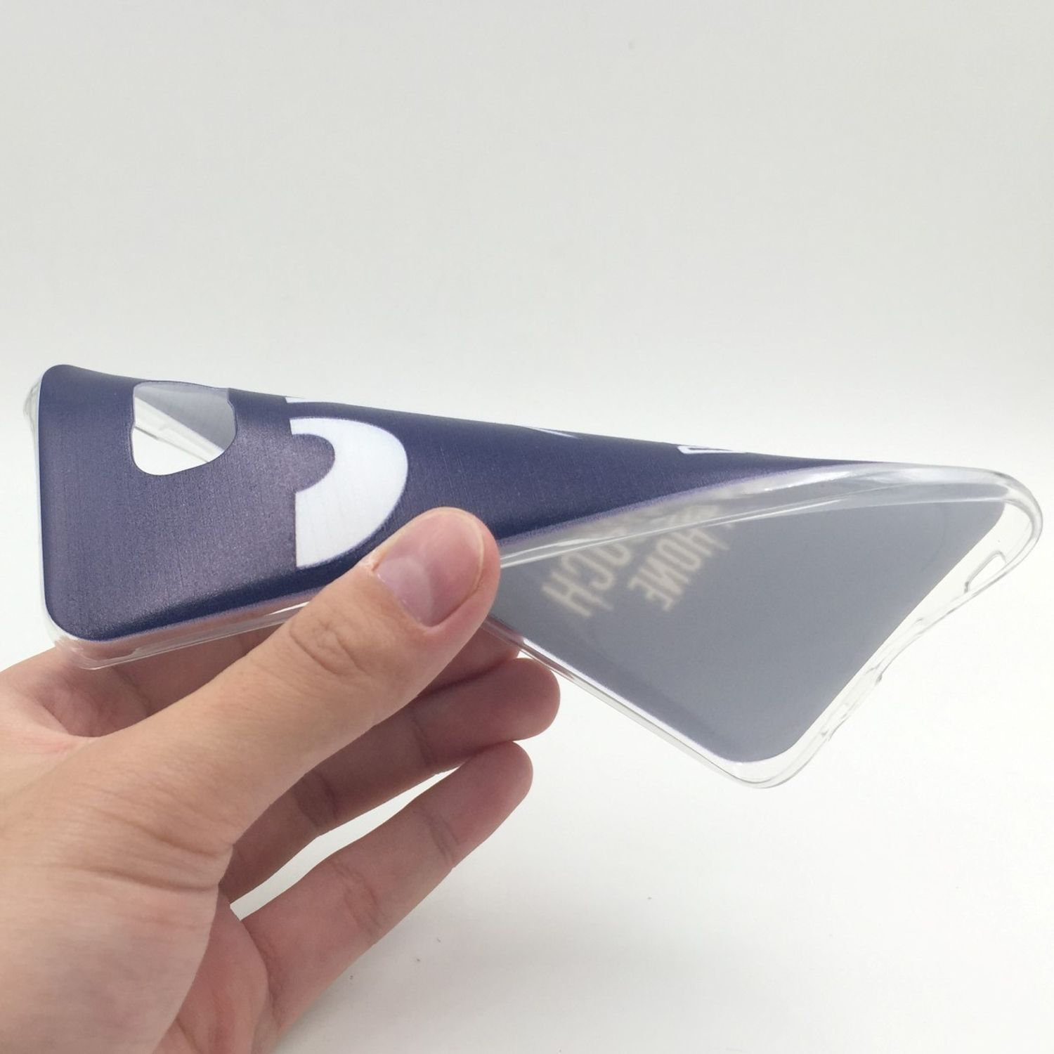 Hand hält eine marineblaue Handyhülle mit weißem Design. Weißer Hintergrund.