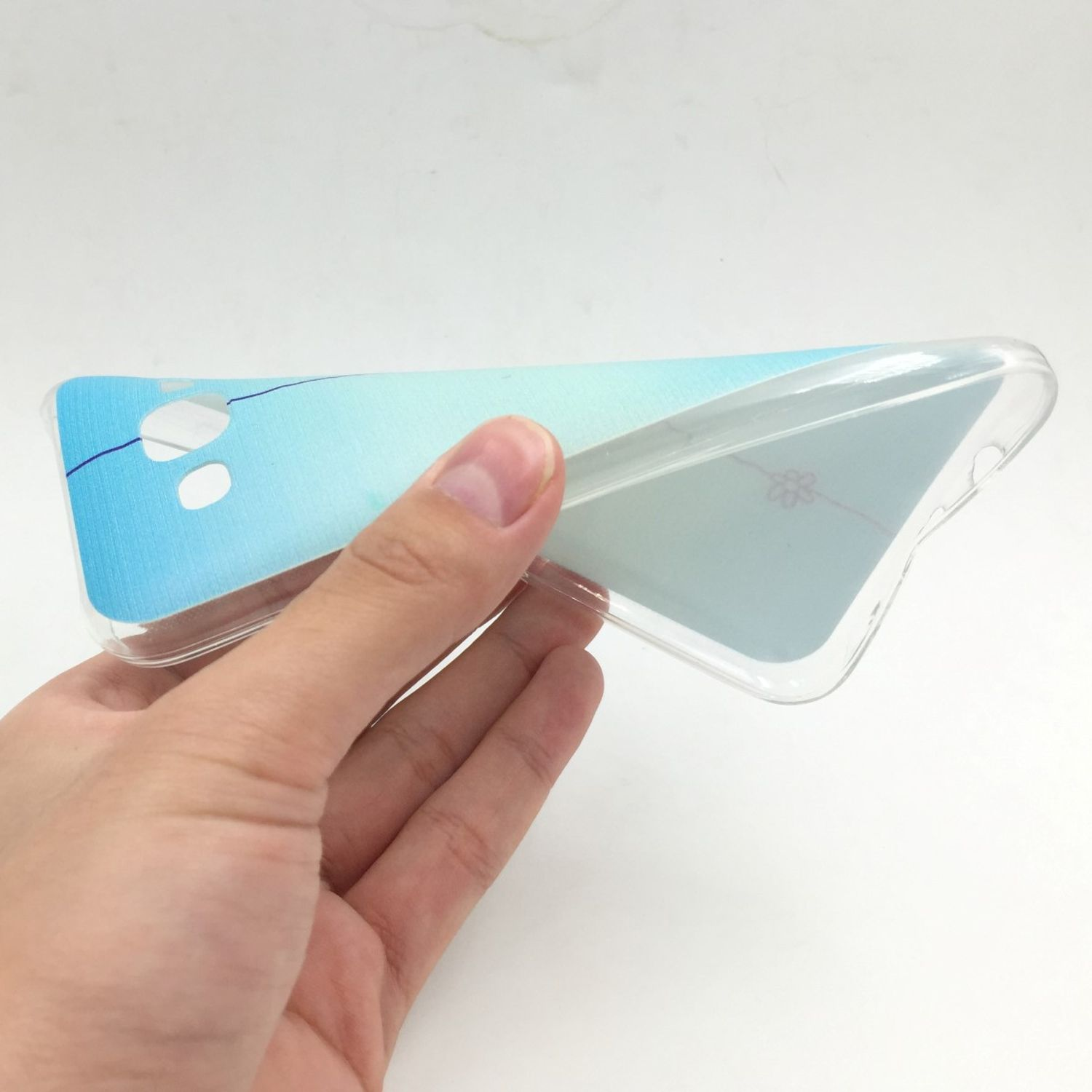Hand hält Handyhülle mit blau-weißem Farbverlauf.