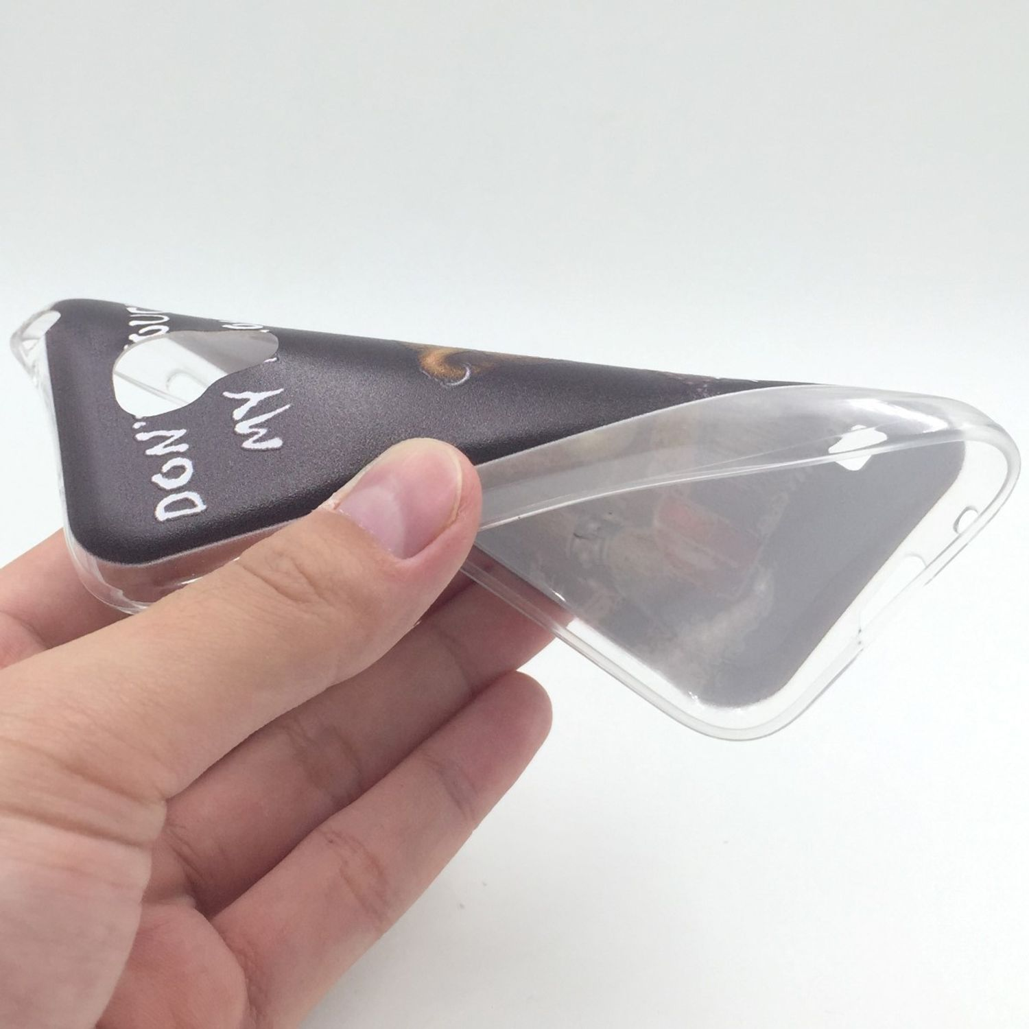 Hand hält eine transparente Handyhülle mit schwarzem Design, auf dem steht: „FASS MEIN TELEFON NICHT AN“.