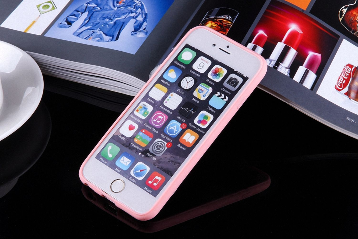 iPhone in rosa Hülle. Telefon liegt auf glänzender Oberfläche. Lippenstift und andere Gegenstände im Hintergrund.