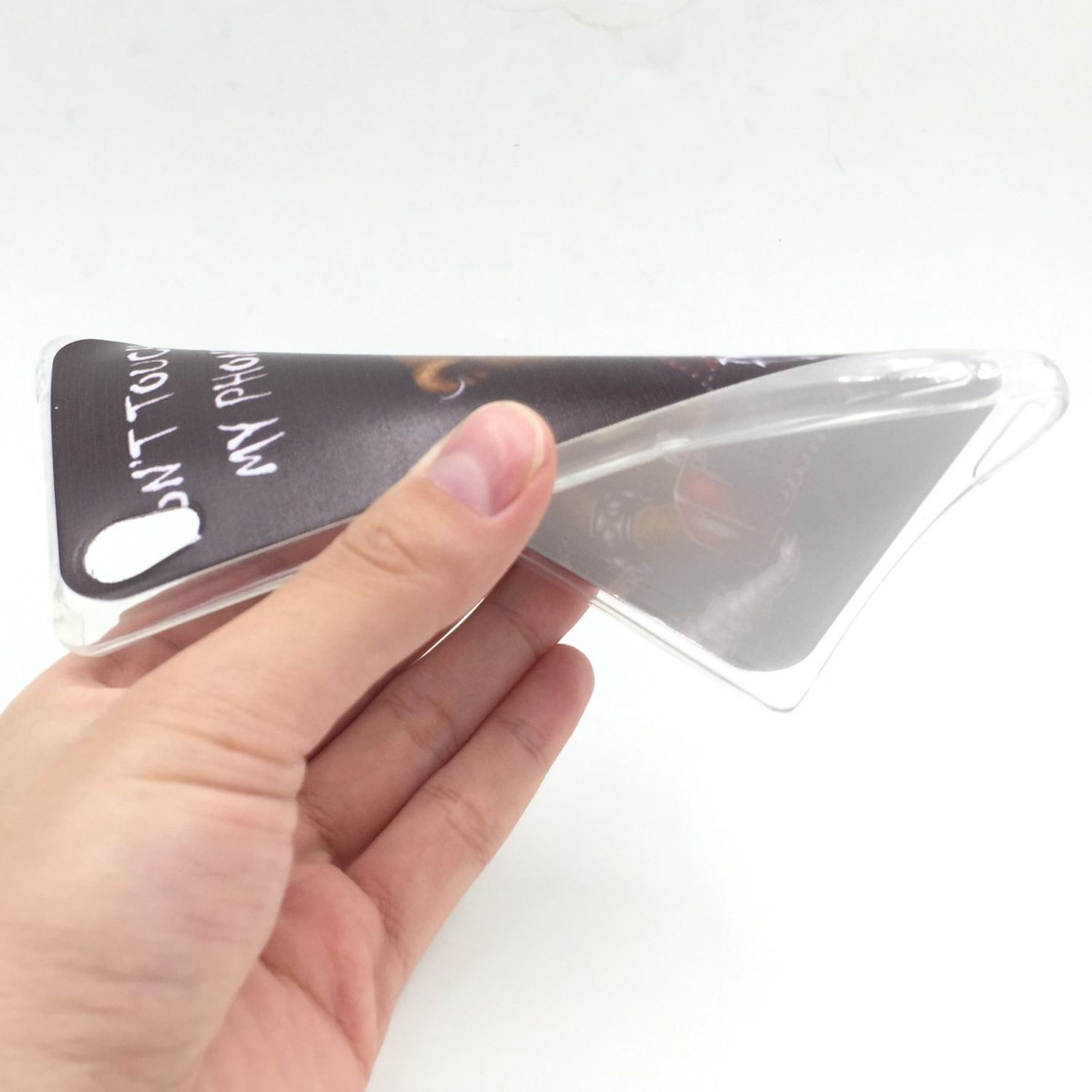 Eine transparente Handyhülle. Eine Hand hält die transparente Handyhülle und zeigt ein Bild im Inneren.