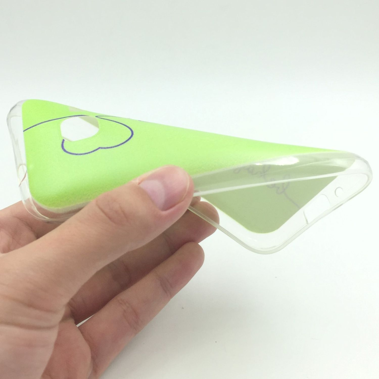 Hand hält transparente Handyhülle mit grünem Design. Weißer Hintergrund.