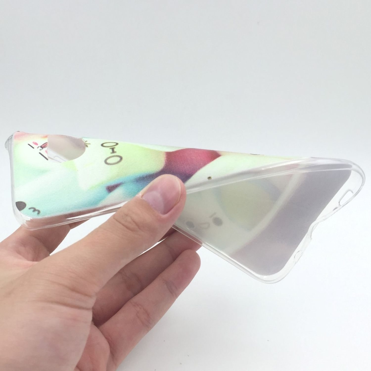 Hand hält eine transparente Handyhülle mit Design. Weißer Hintergrund. Hülle ist flexibel und transparent.